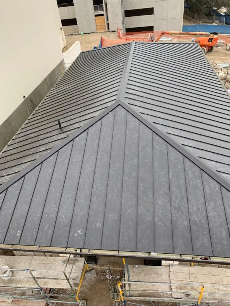 Commercial metal roof construction with crane equipment in Keller